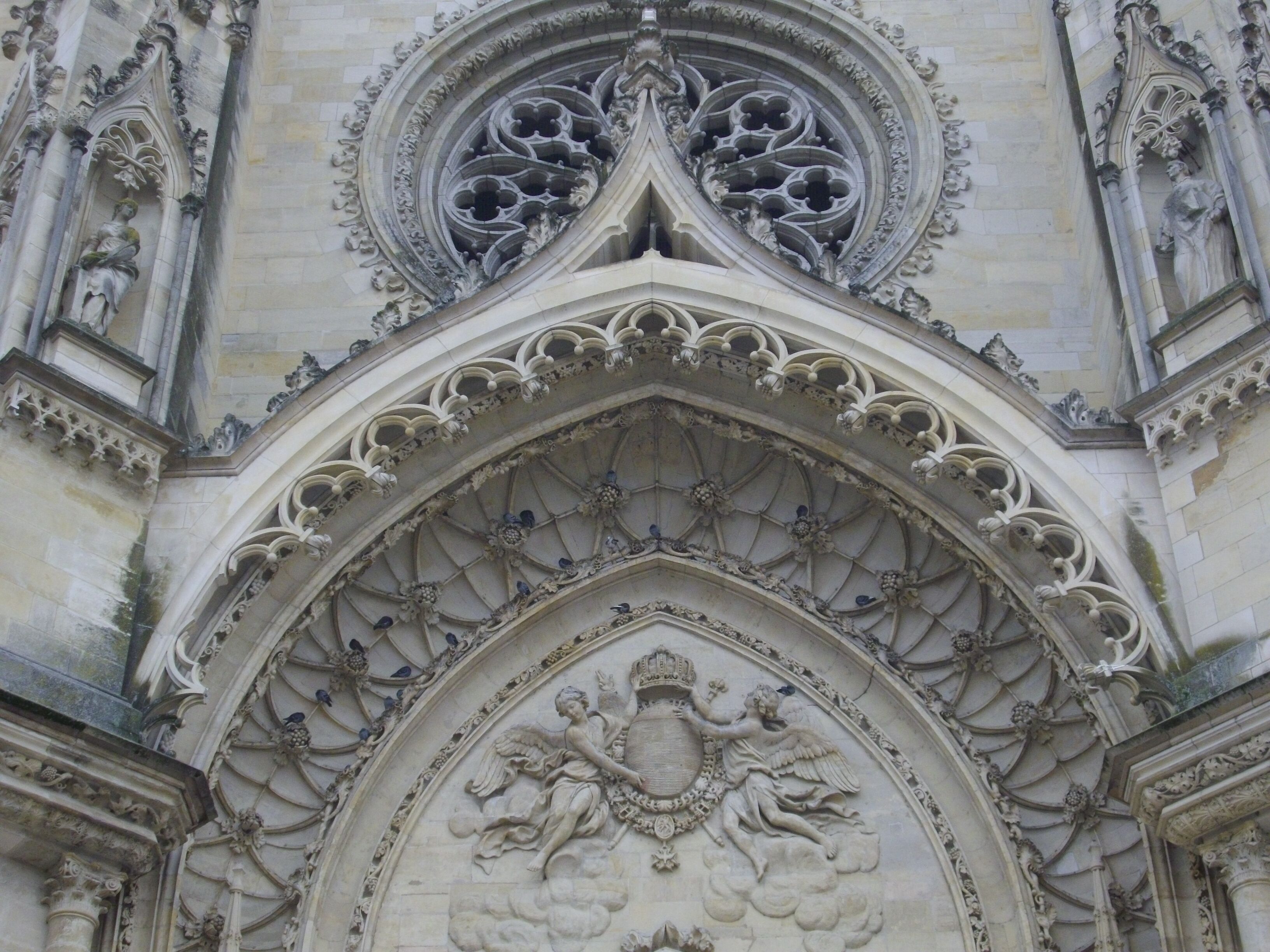 Fachada de piedra detallada con intrincados adornos y un arco pronunciado.