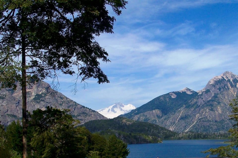 A mountain range with a lake in the foreground and snow-capped peaks in the background.
