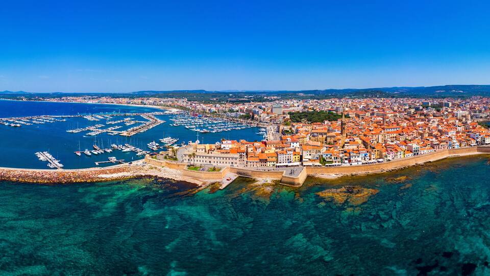 Aerial view over Alghero old town, cityscape Alghero view on a beautiful day with harbor and open sea in view. Alghero, Italy. Panoramic aerial view of Alghero, Sardinia, Italy.