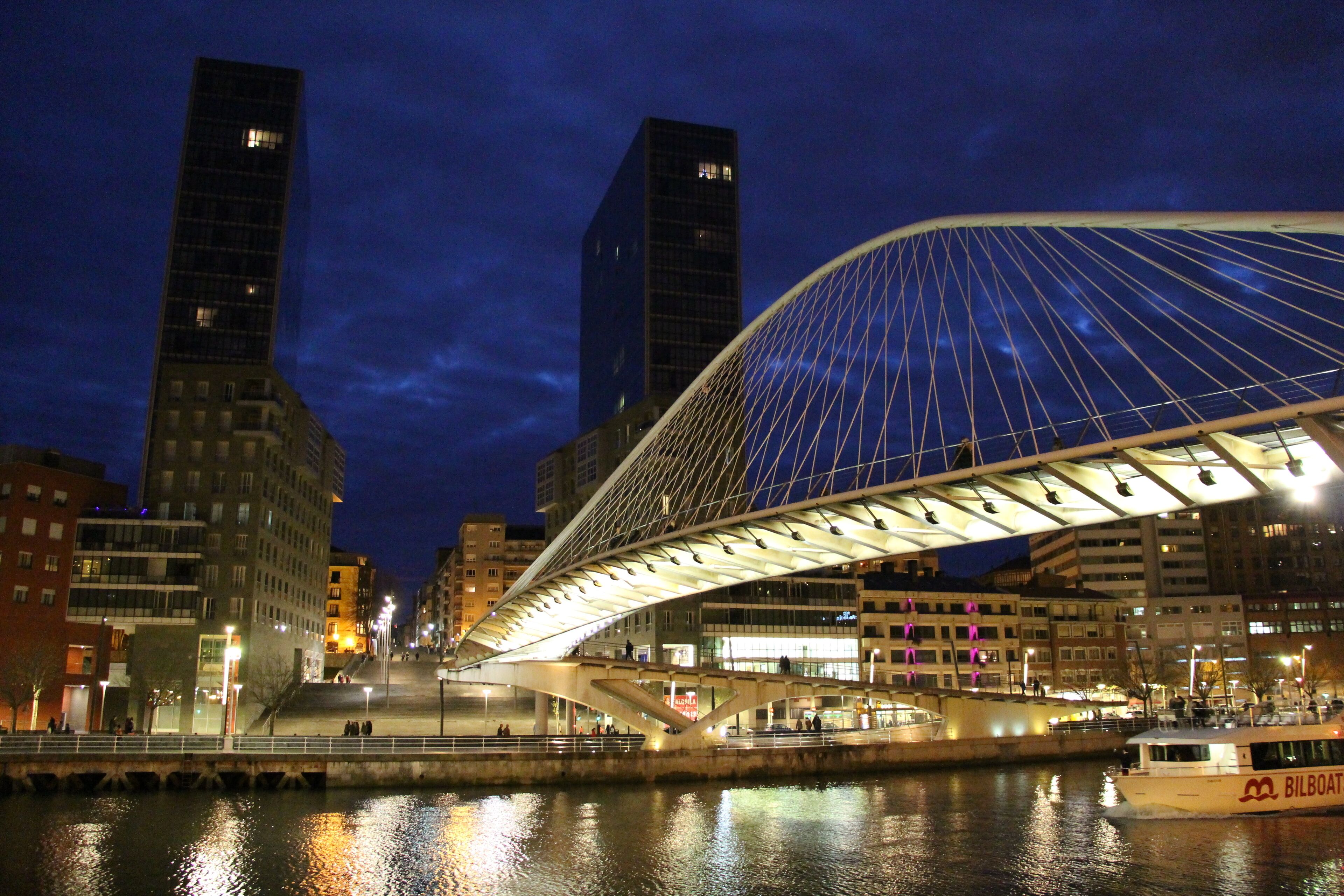 (Abando) Zubizuri Zubizuri - "White Bridge" - footbridge. Arch. Santiago Calatrava 1990-97. In the background, Isozaki Atea, the tallest residential buildings in the city. Arch. Arata Isozaki 2004-08.