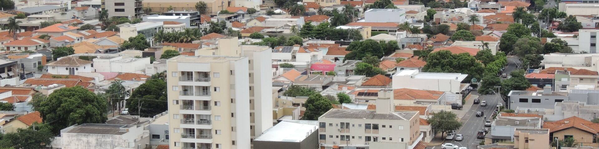 A densely built urban area with a mix of high-rise and low-rise buildings, a variety of roof colors, and a network of streets.