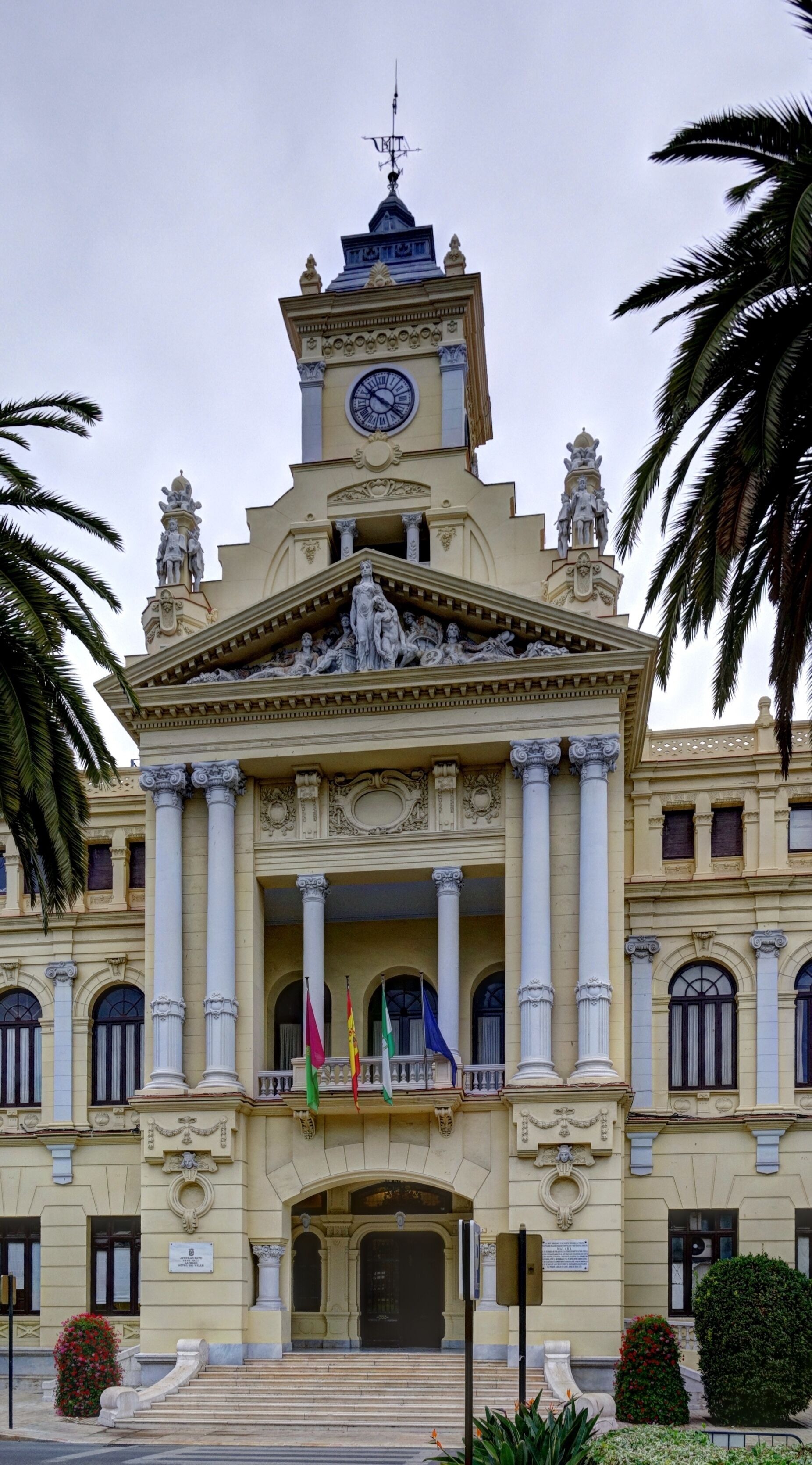 A grand building with a clock tower, columns, and statues.
