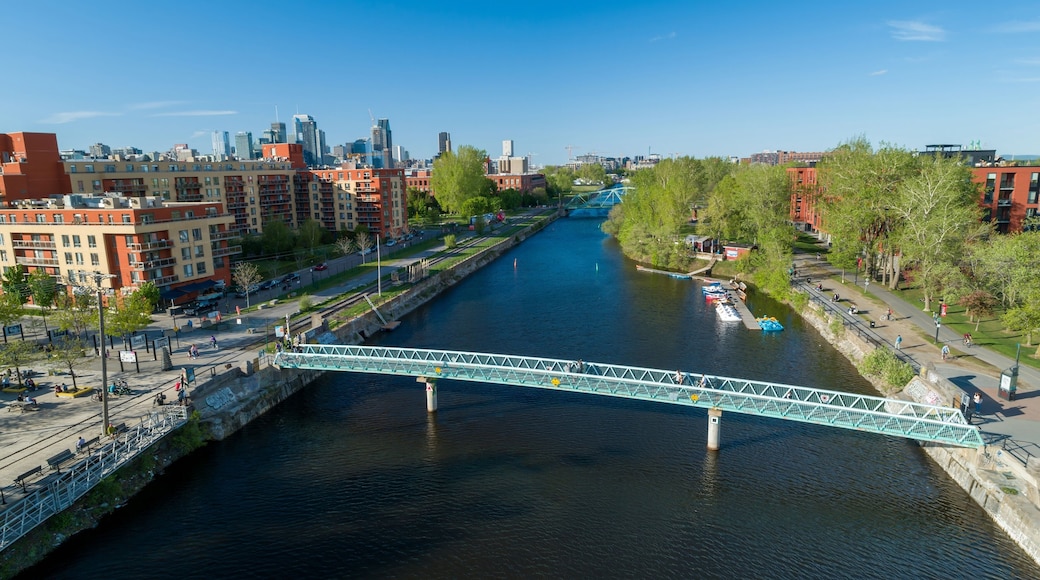 Aerial view of the Lachine Canal in Atwater, Montreal, Quebec, Canada. People are walking and biking along the canal and crossing the bridges for recreation and transportation.
