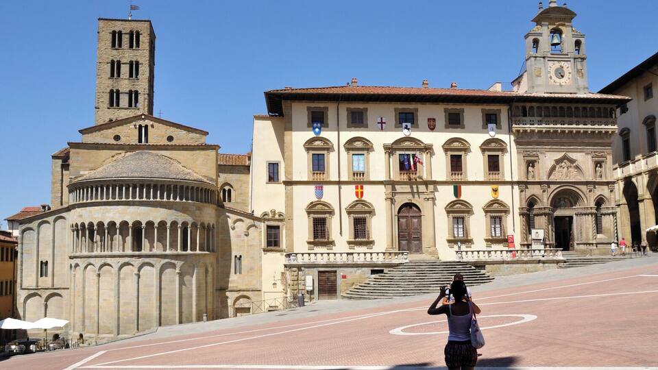 A historic building with a bell tower and a large arched entrance.