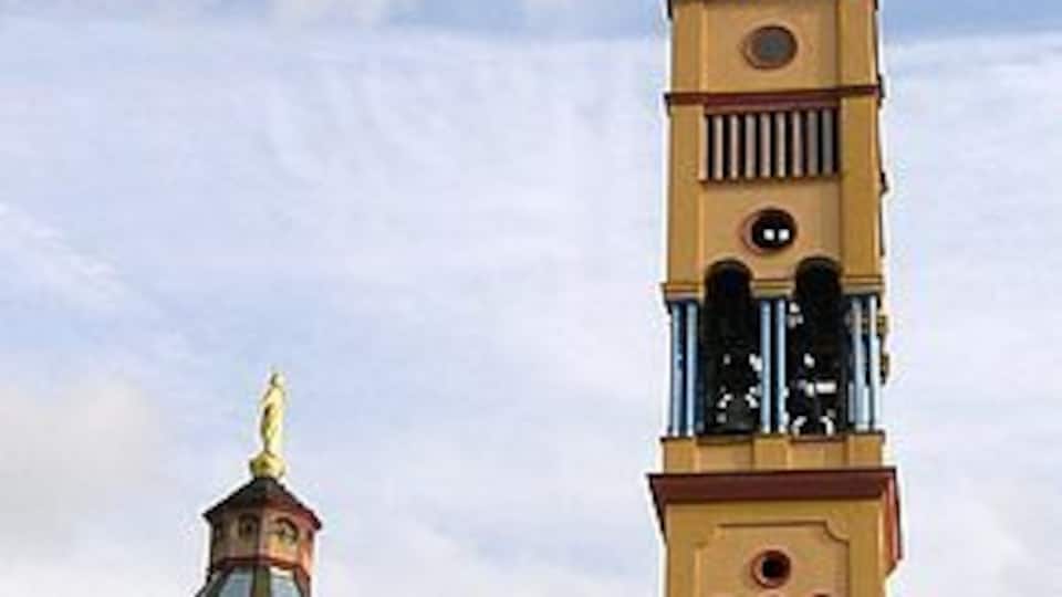 A tall tower with a clock and a smaller building with a dome.