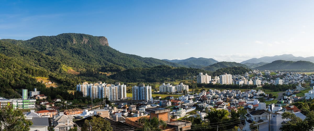 A cityscape with a prominent mountain range in the background.