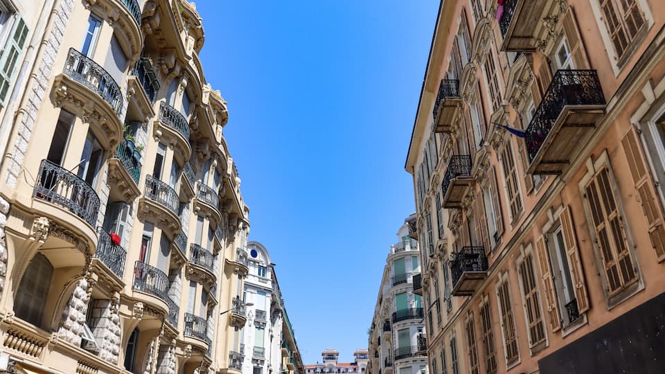 A street with ornate buildings and a clear blue sky.