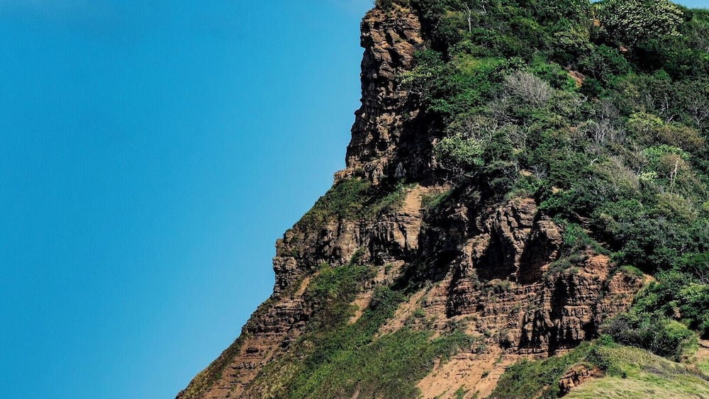 Lush green headland and inviting ocean on this beautiful beach. #BeachBound #beachtips