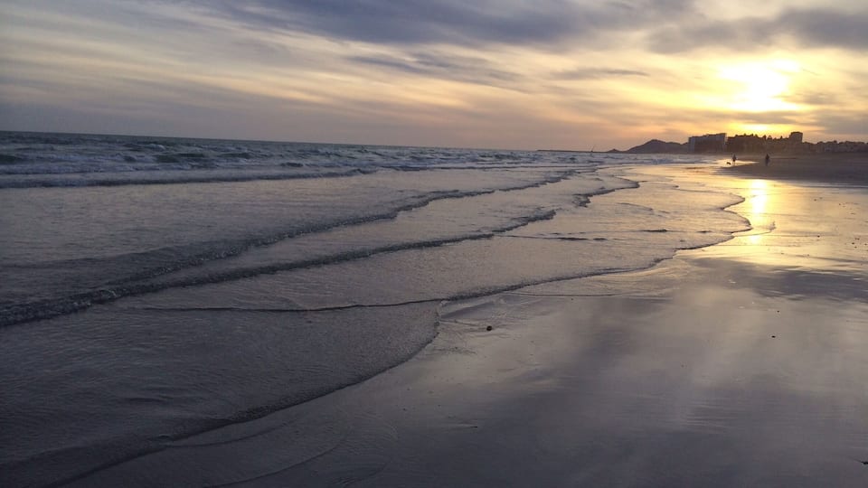 The essence of life is watching the sunset while walking on the beach.