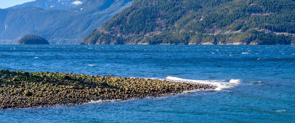 Fantastic view over ocean, snow mountain and rocks at Sechelt inlet in Vancouver, Canada.