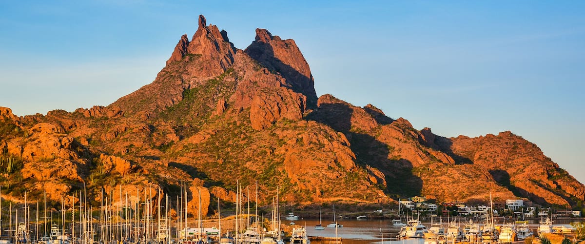 A mountainous landscape with a marina filled with boats.