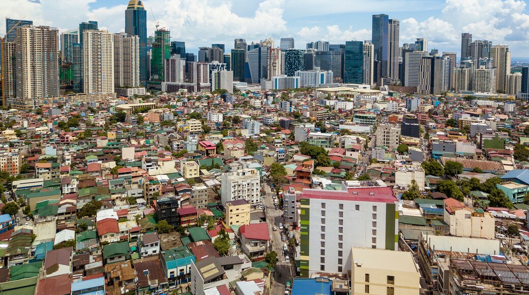 Makati, Philippines - July 2020: Aerial of Fort Bonifacio skyline in the back, and districts of Pitogo,South Cembo and Guadalupe, Makati in front.