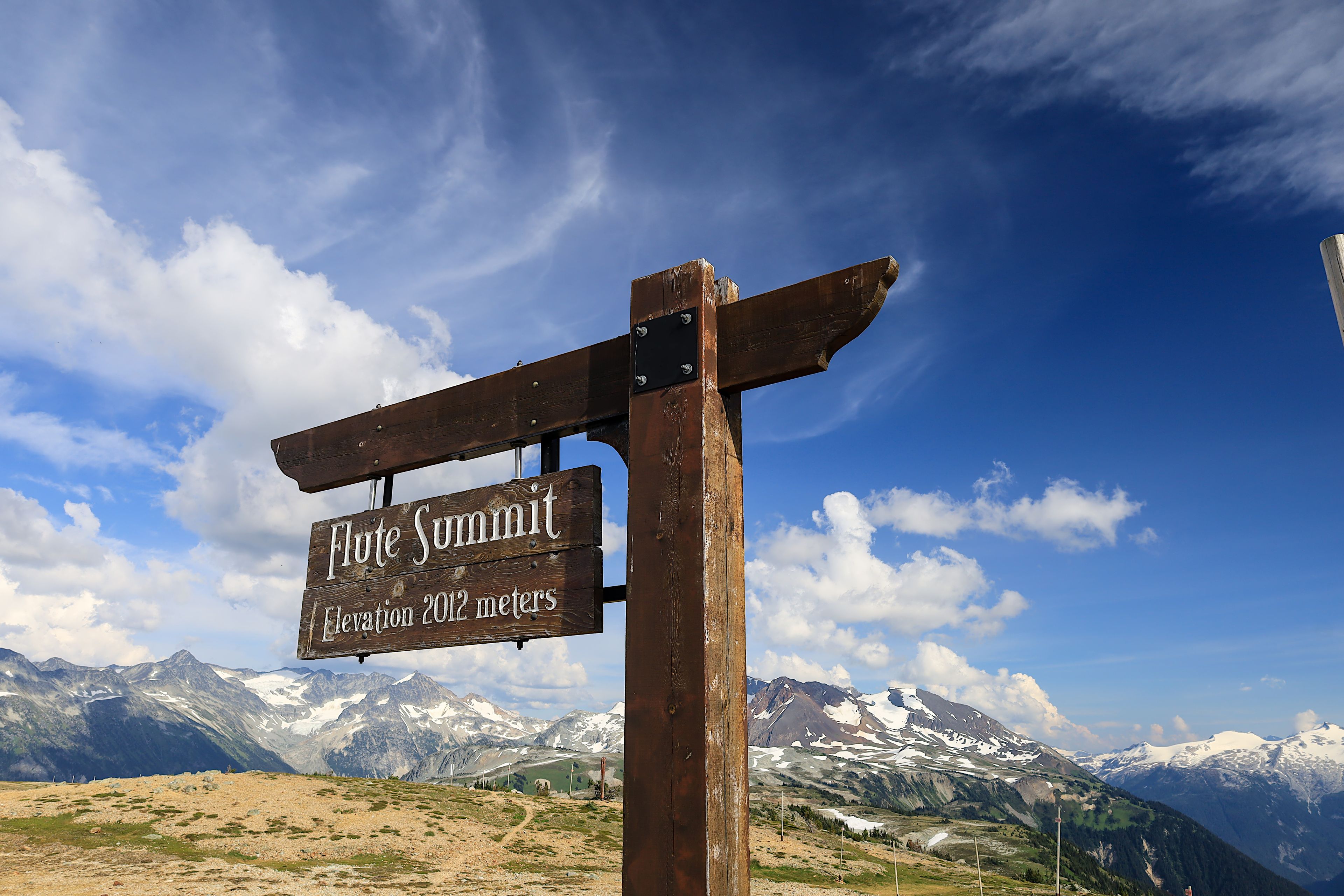 Wooden signpost on Flute Summit in Whistler ski area, British Columbia, Canada.