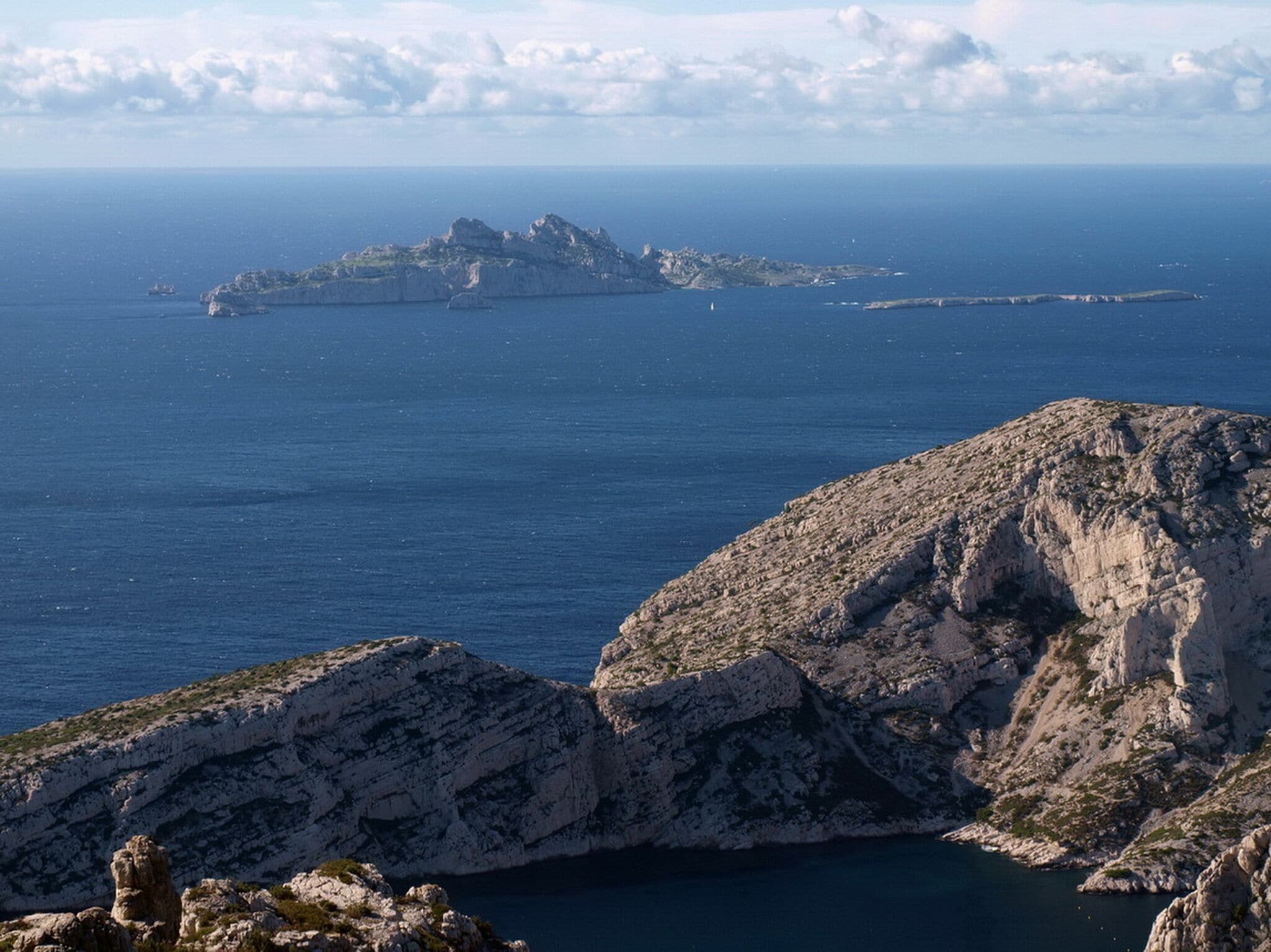 A rugged coastline with rocky outcrops and a distant island.