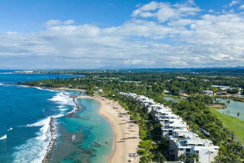 Un resort costero con playa, océano y campo de golf.