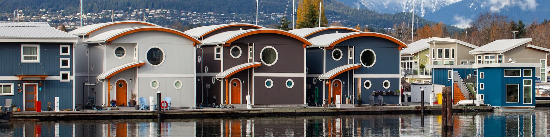 Cute, colourful floating houseboats line the docks in Mosquito Creek Marina, North Vancouver, British-Columbia. This alternative housing is growing in popularity with a challenging housing market.