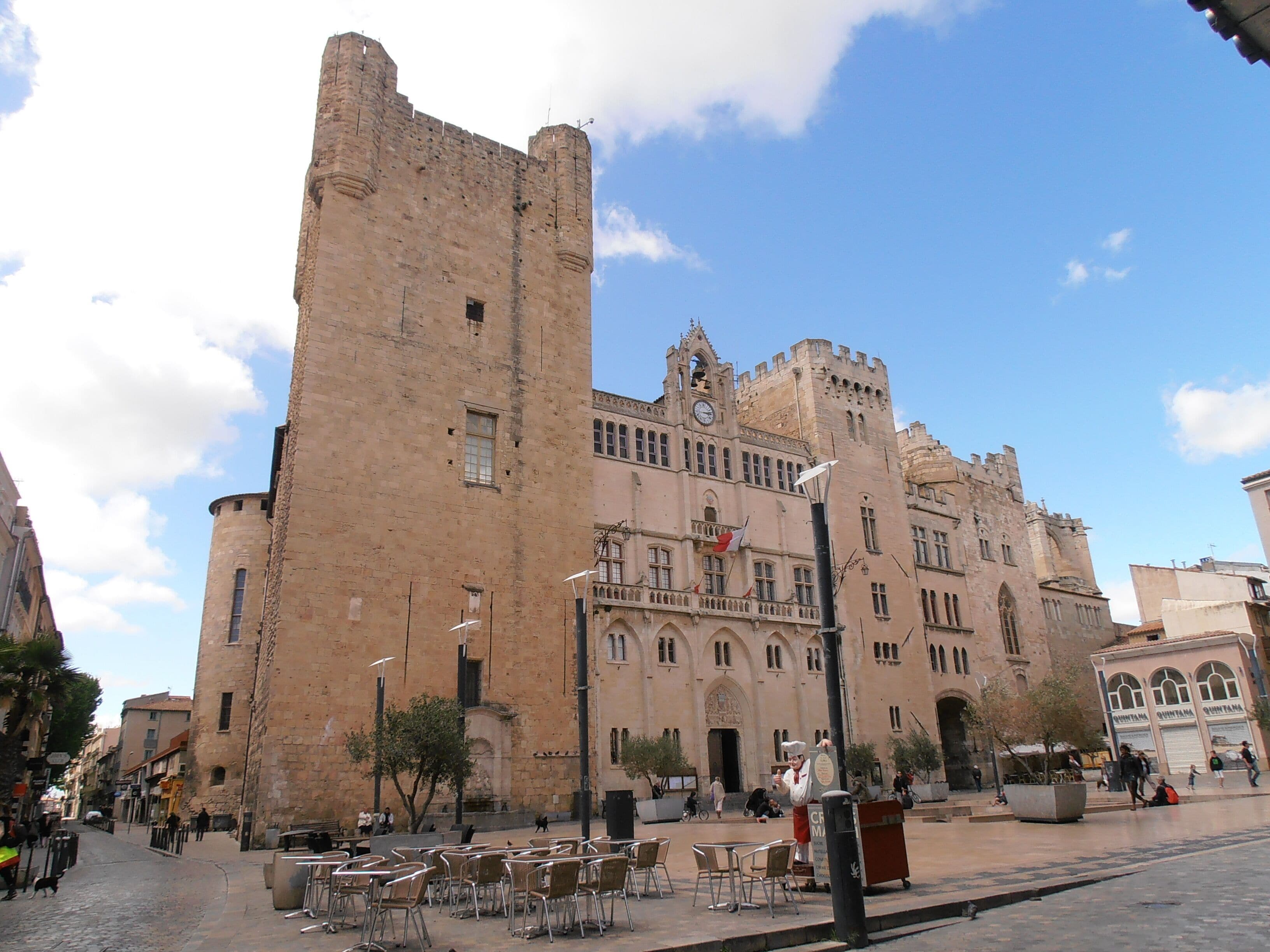 Un bâtiment historique doté d’une haute tour et de fenêtres en arc.