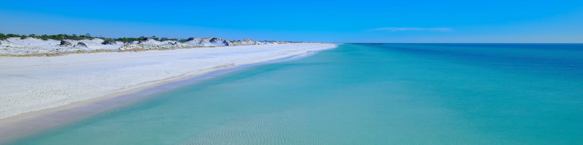 Calm emerald gulf of mexico water sugar white sand dunes at St. Andrews State Park Florida USA