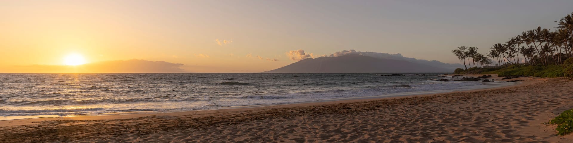 View of Pacific Ocean and golden sun at twilight from the sandy shore of Keawakapu Beach; Kihei, Wailea, Maui, Hawaii, United States of America