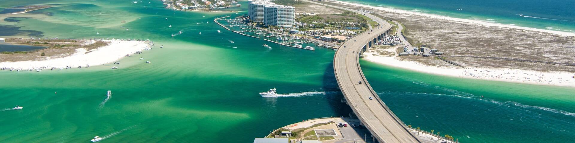 A coastal city with a marina, a bridge, and a beach.