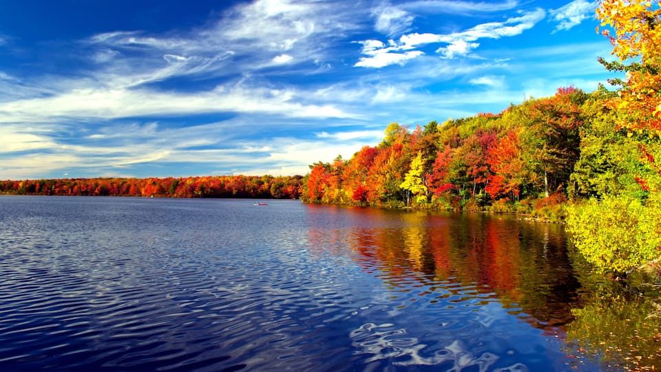 Colorful fall foliage surrounds a lake in the Poconos of Pennsylvania.