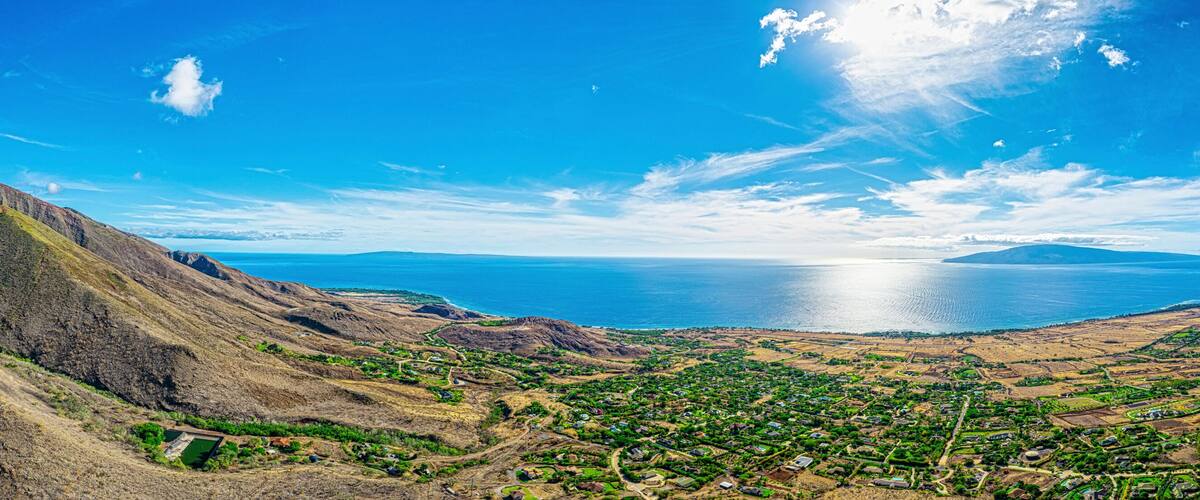 A mountainous landscape with a coastal town and a large body of water.