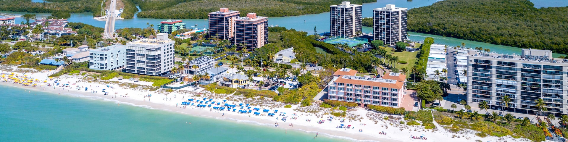 Aerial Drone View in Naples, Florida with the Coast and Sandy Beach in the Foreground on the Gulf of Mexico and Blue Water Bays in the Background Among Mangroves