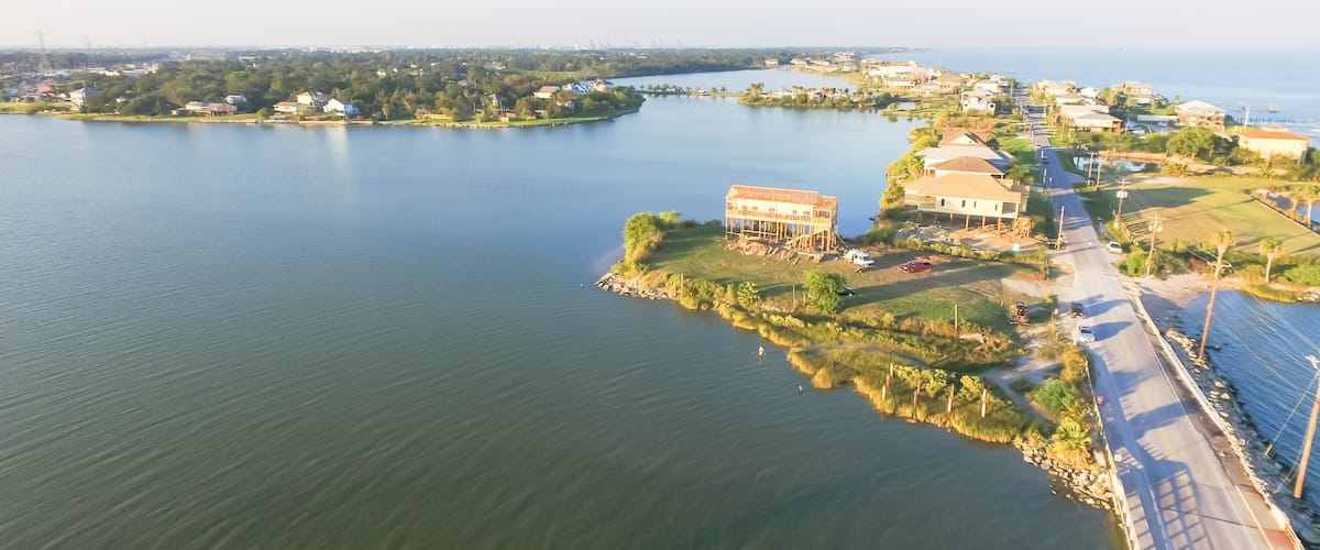 Panorama aerial view of Seabrook city near Texas Gulf Coast and Clear Lake. Waterfront harbor town with pier. Wooden vacation house under construction. Real estate and beach travel background