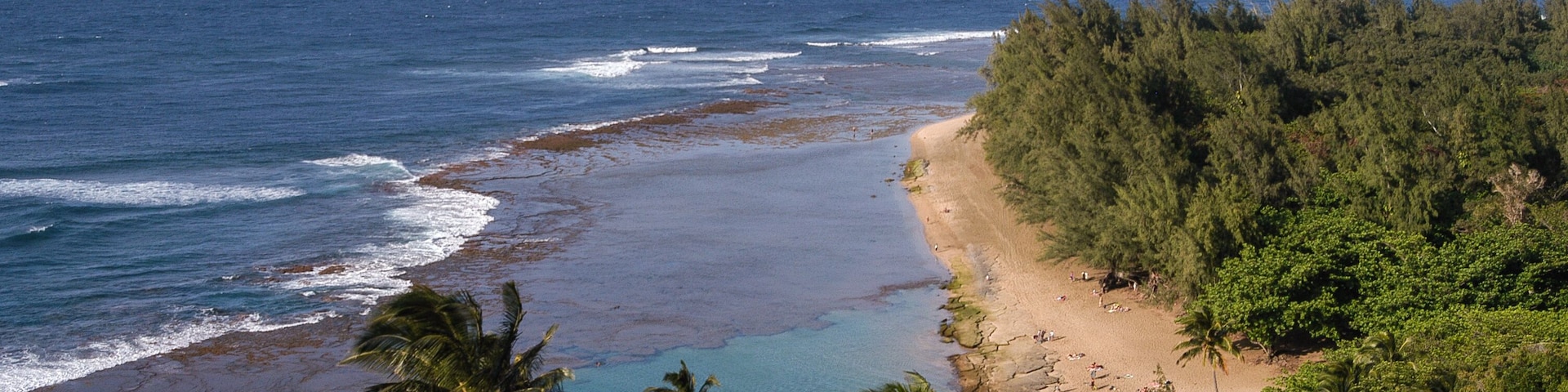 Golden sand Kee Beach and aquamarine colored lagoon from the Kalalau Trail in Haena State Park (end of the road) on Kauai, Hawaii, USA