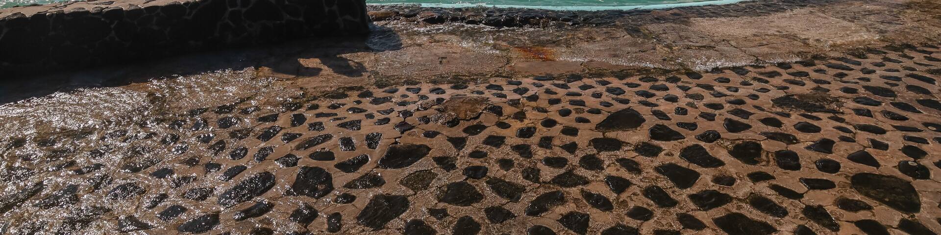 Visitors enjoy the waves crashing over the edge of Ali'i Saltwater Swimming Pool on Hawaii's Big Island.