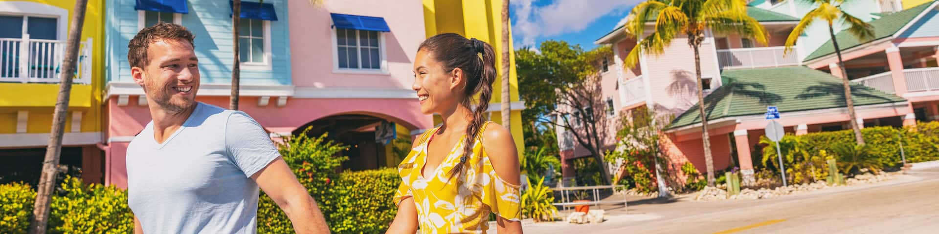 Summer florida vacation couple walking in city street with colorful beach houses wooden cottages at Fort Myers Beach traditional color house - panoramic banner.