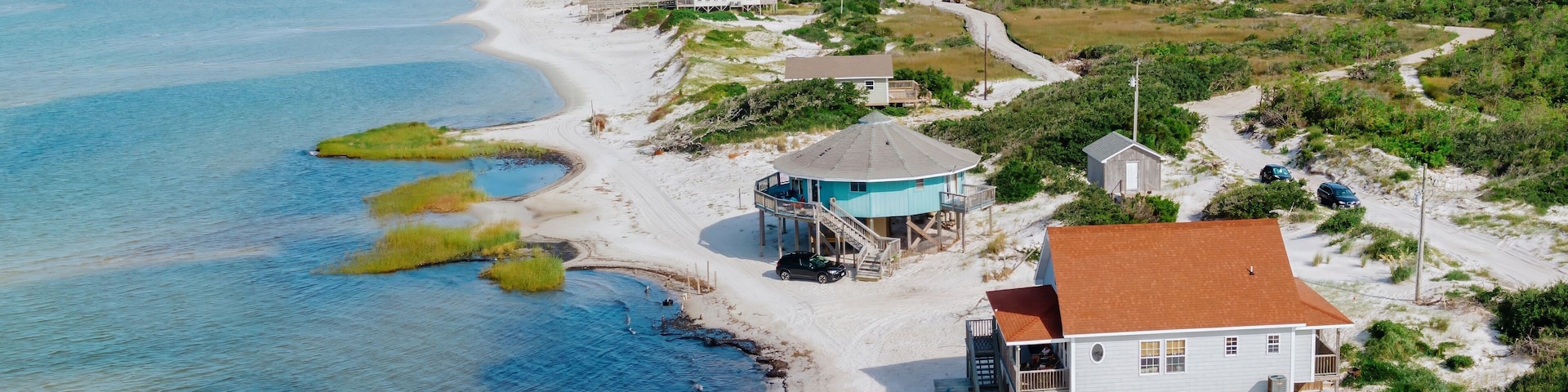 Holiday homes on stilts on sandunes at the waters edge on Cedar Island, North Carolina, United States.