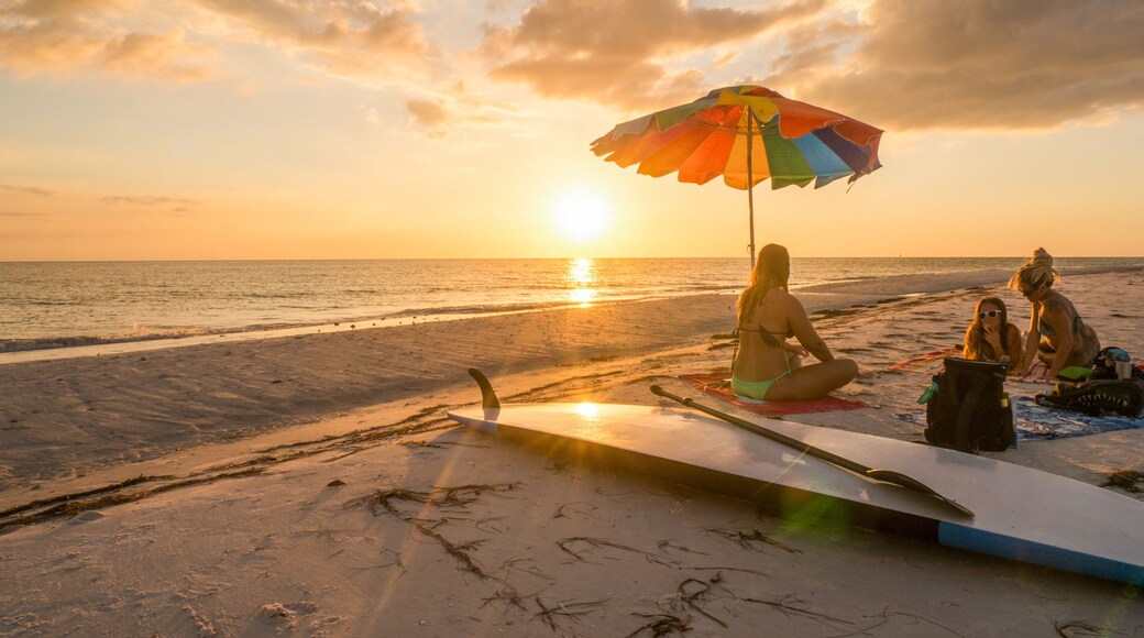 LOVERS KEY, FORT MYERS BEACH, FLOIRDA/USA 11/4/15: Girlfriends enjoying the sunset on the beach underneath a rainbow unbrella.