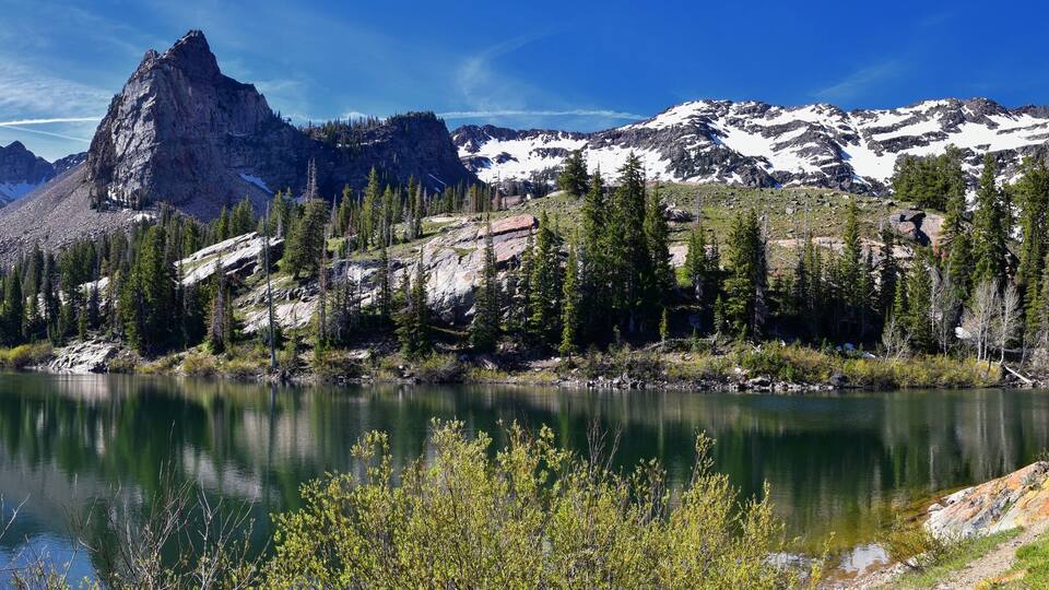 A mountain lake surrounded by rugged mountains and dense forests.