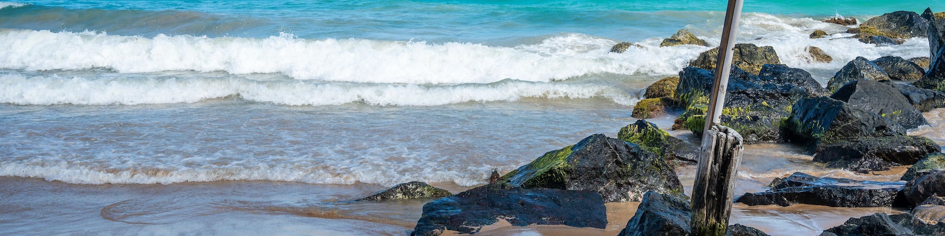 Puerto Rican flag waves on Condado Beach, San Juan, Puerto Rico, with turquoise waves crashing on shore, scenic tropical seascape capturing island pride, travel, and Caribbean beauty (February 2025)