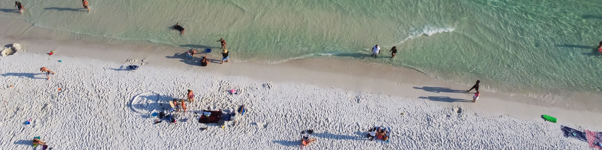 Panorama diverse crowed people swimming, relaxing on sugar white sandy shoreline, turquoise water, South Walton beach, Destin, Florida, USA, colorful tents, canopy, lounge chairs