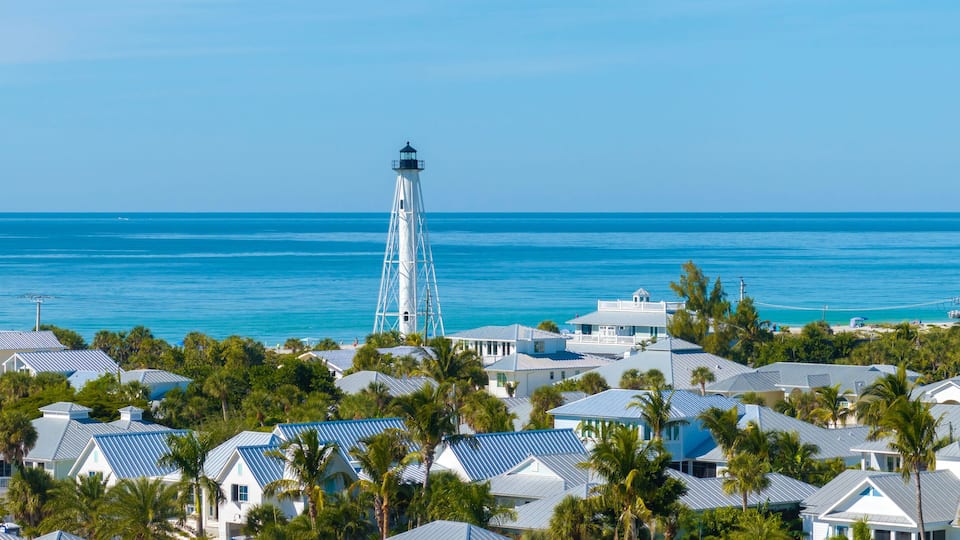 Famous lighthouse on ocean shore and expensive residential houses in island small town Boca Grande on Gasparilla Island in southwest Florida