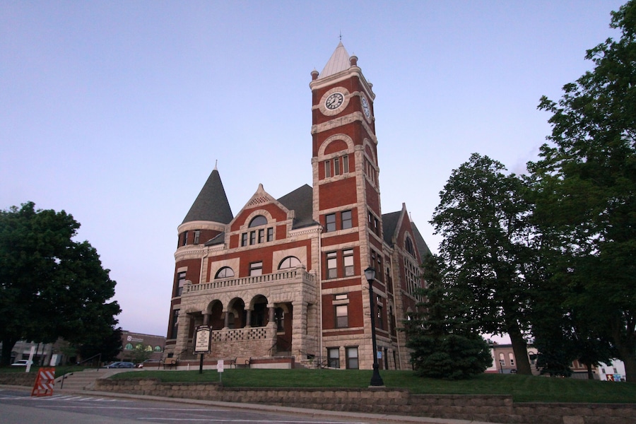 A large, historic building with a clock tower, arched windows, and a prominent entrance.