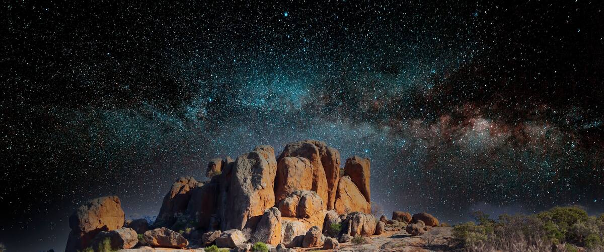 A rocky outcrop with a starry night sky.
