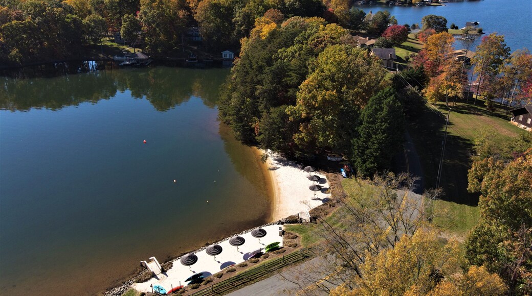 Une vue sur le lac, avec un quai, des tables de pique-nique et des arbres aux couleurs automnales.