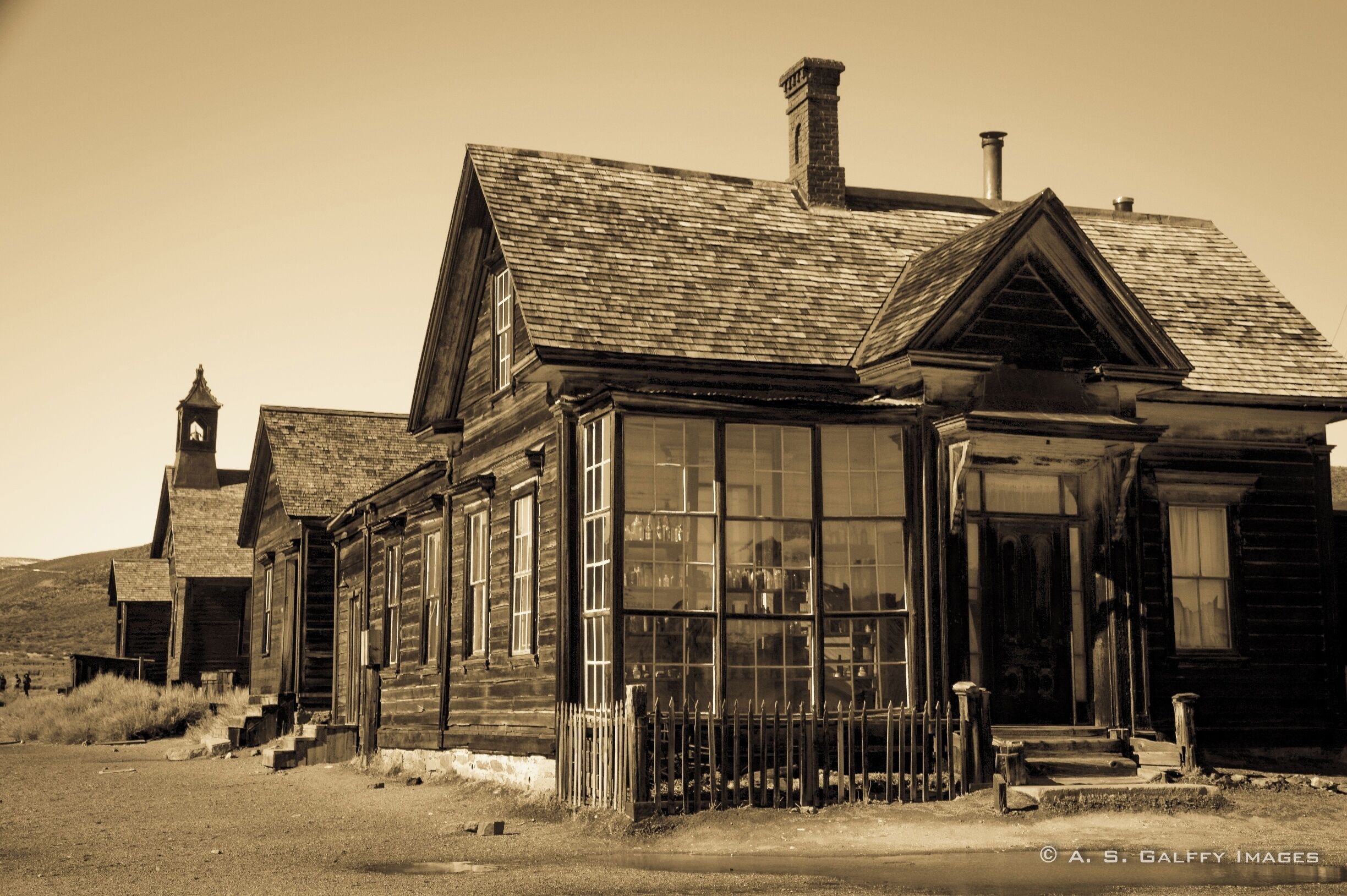 A historic wooden building with large windows and a bell tower.