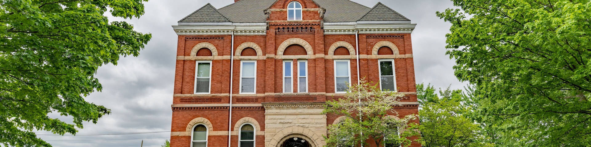 Barry County Courthouse in Hastings, Michigan with green trees and blue sky