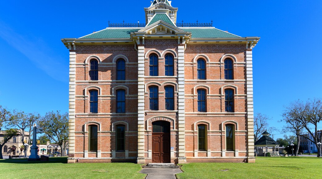 A large brick building with a green roof and multiple arched windows.