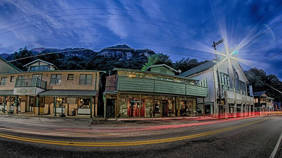 A street with historic buildings, a mountain in the background, and a starry sky.