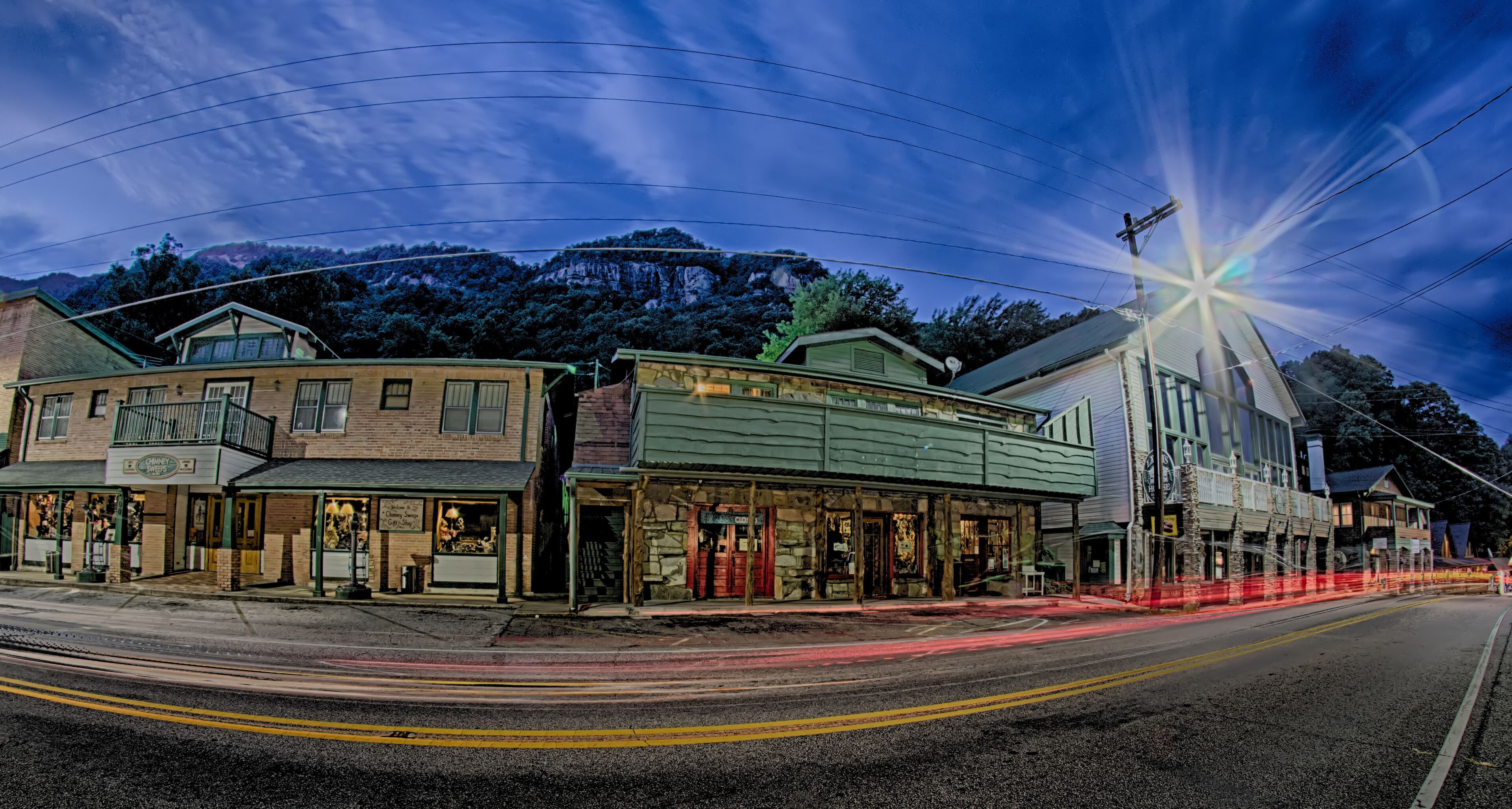 A street with historic buildings, a mountain in the background, and a starry sky.