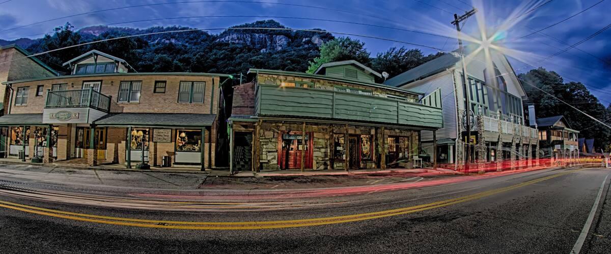 A street with historic buildings, a mountain in the background, and a starry sky.
