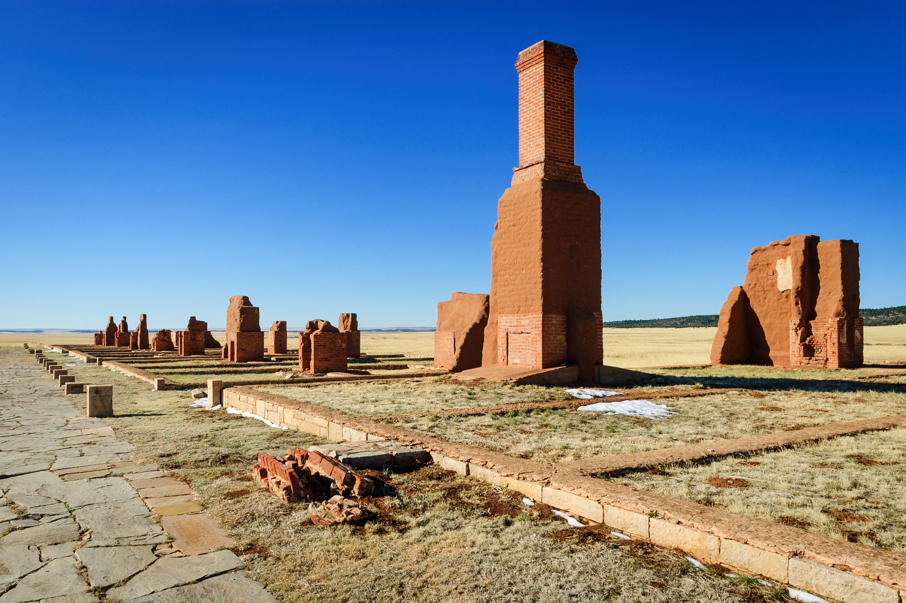 Ruinas antiguas de ladrillo bajo un cielo azul brillante.