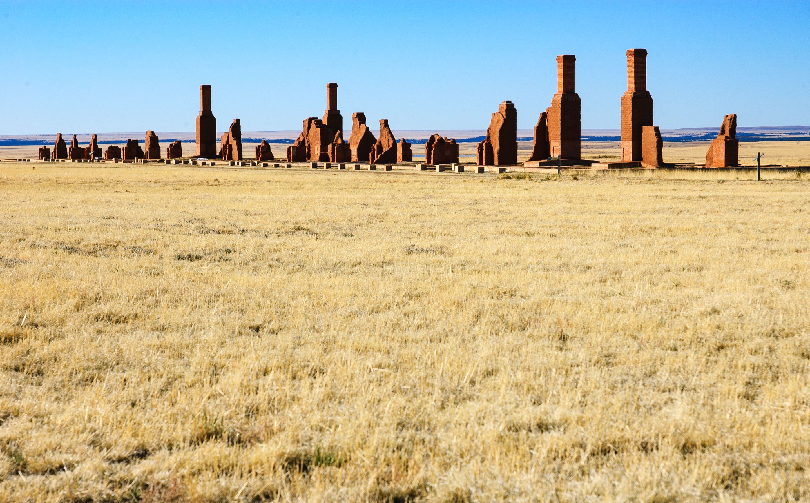 Un campo de estructuras antiguas de ladrillo rojo con un cielo azul despejado.