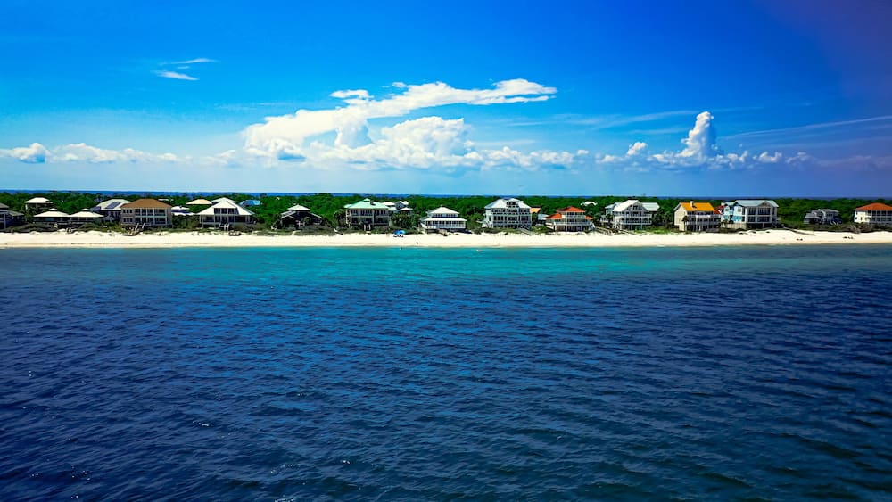 A coastal resort with beachfront villas and a clear blue sky.