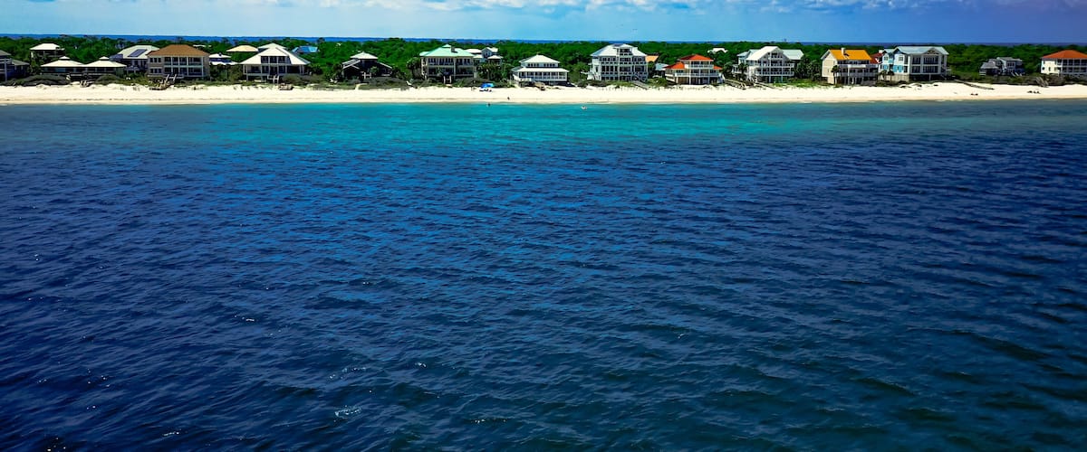 A coastal resort with beachfront villas and a clear blue sky.